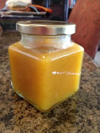 calamondin marmalade jar filled with orange marmalade on a granite countertop