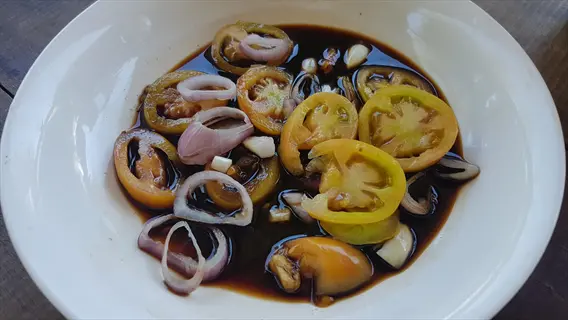 filipino dipping sauce with tomatoes, onions, and garlic in a white bowl