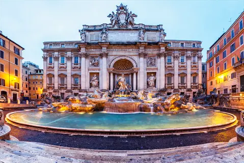 trevi fountain in rome illuminated at dusk with cascading water and ornate baroque facade